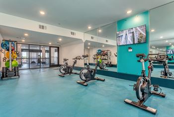 A room with exercise bikes and a television.